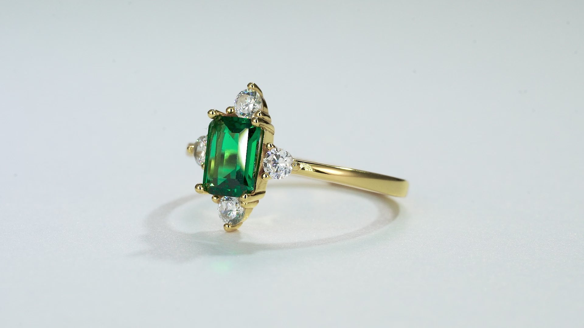 Gold emerald ring with CZ accents and emerald centerpiece